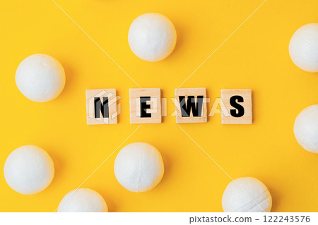 A yellow background with a large group of white balls scattered around it 122243576