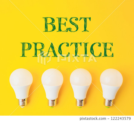 Four white light bulbs arranged in a row on a yellow background Four white light bulbs arranged in a row on a yellow background 122243579
