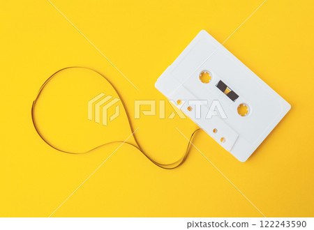 A white cassette tape is laying on a yellow background A white cassette tape is laying on a yellow background 122243590