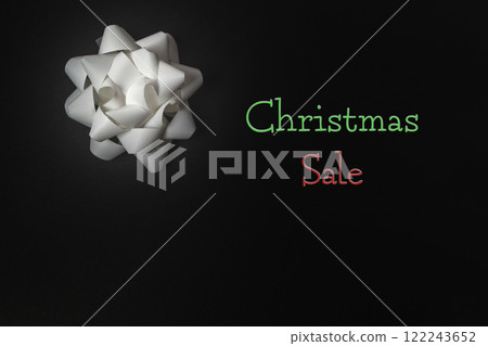 Silver bow on black background announcing Christmas Sale Silver bow on black background announcing Christmas Sale 122243652