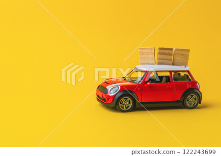 Red toy car with wooden boxes on top of it Red toy car with wooden boxes on top of it 122243699