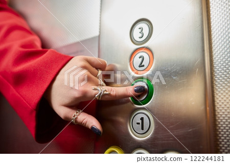 Pressing the elevator button in contemporary high rise buildings signifies modern urban convenience 122244181