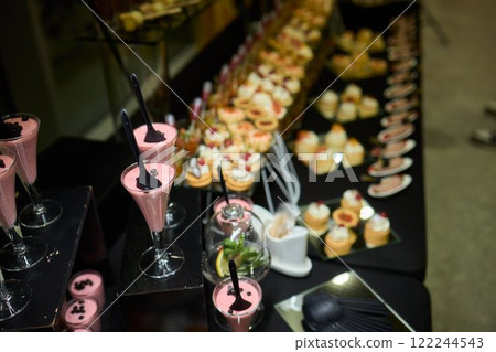 An Elegant Assortment of Gourmet Desserts and Savory Snacks Beautifully Arranged on Table 122244543