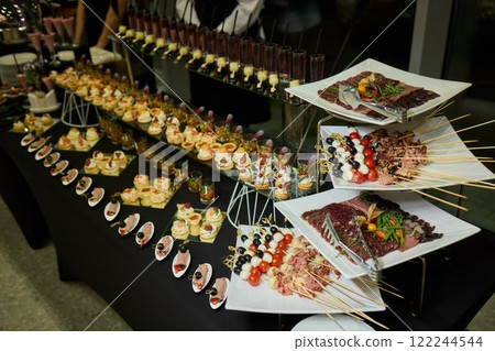 An Elegant Assortment of Gourmet Desserts and Savory Snacks Beautifully Arranged on Table 122244544