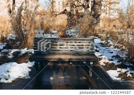 Wooden Bench in winter public park. Benches for rest and relaxation. Sunny day Wooden Bench in winter public park. Benches for rest and relaxation. Sunny day 122244587