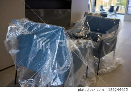 Plastic covered chairs in a modern office setting create an intriguing aesthetic Plastic covered chairs in a modern office setting create an intriguing aesthetic 122244655
