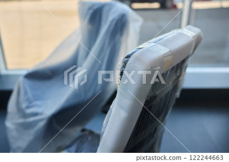 Plastic covered chairs in a modern office setting create an intriguing aesthetic Plastic covered chairs in a modern office setting create an intriguing aesthetic 122244663