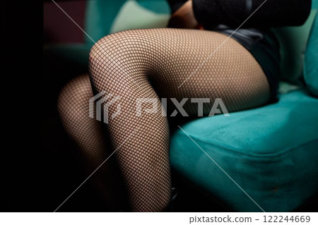 An Elegant Fashion Stock Image Featuring Stylish Fishnet Tights and a Model Posing in a Unique Way An Elegant Fashion Stock Image Featuring Stylish Fishnet Tights and a Model Posing in a Unique Way 122244669