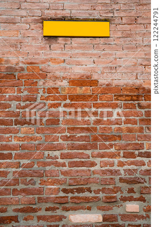 Rustic brick wall with a vibrant yellow sign Rustic brick wall with a vibrant yellow sign 122244791