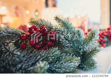 A holiday garland with frosted green branches and red berries A holiday garland with frosted green branches and red berries 122244794