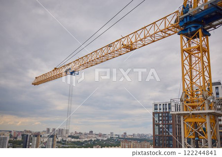 A construction crane is towering over the stunning city skyline, showcasing modern development 122244841