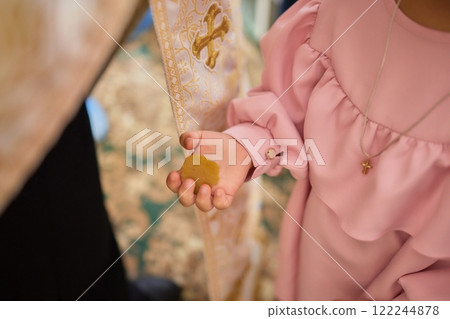 A Baptism Ceremony featuring a Childs Hand and a Priests Blessing takes place 122244878