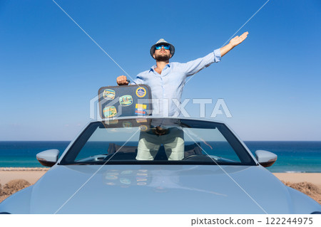 Successful young businessman on a beach. Man standing in the cabriolet classic car. 122244975