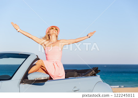 Happy young woman travel by car by the sea 122245011
