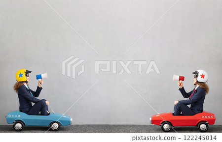 Successfull businesswomen driving toy car outdoor 122245014