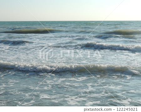 the tide of the sea or ocean in the soft rolling of a foamy wave on a rocky beach on a sunny clear day, a beautiful deserted seascape with a smooth surf, silver-blue waves running onto a pebble shore the tide of the sea or ocean in the soft rolling of a foamy wave on a rocky beach on a sunny clear day, a beautiful deserted seascape with a smooth surf, silver-blue waves running onto a pebble shore 122245021