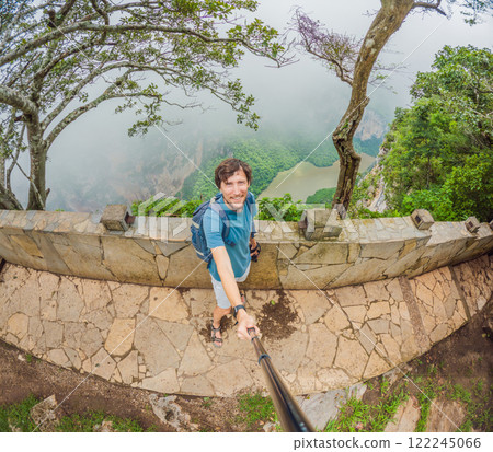 Male tourist exploring Sumidero Canyon National Park, Mexico. Adventurous traveler enjoying breathtaking views of cliffs and river in this iconic natural landmark. Concept of nature, exploration, and Male tourist exploring Sumidero Canyon National Park, Mexico. Adventurous traveler enjoying breathtaking views of cliffs and river in this iconic natural landmark. Concept of nature, exploration, and 122245066