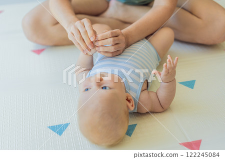 A mother gently massages her baby tiny fingers and palms, promoting relaxation and stimulation. A tender bonding moment focused on care, love, and early development. Baby care, touch therapy, and A mother gently massages her baby tiny fingers and palms, promoting relaxation and stimulation. A tender bonding moment focused on care, love, and early development. Baby care, touch therapy, and 122245084