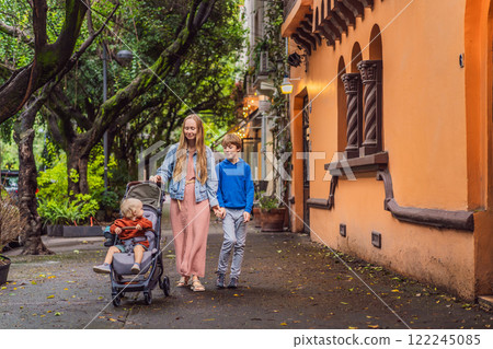Mother with her two sons exploring lush streets of Condesa, Mexico City. Family adventure in a vibrant urban oasis. Travel, family bonding, and urban greenery concept in Latin America Mother with her two sons exploring lush streets of Condesa, Mexico City. Family adventure in a vibrant urban oasis. Travel, family bonding, and urban greenery concept in Latin America 122245085