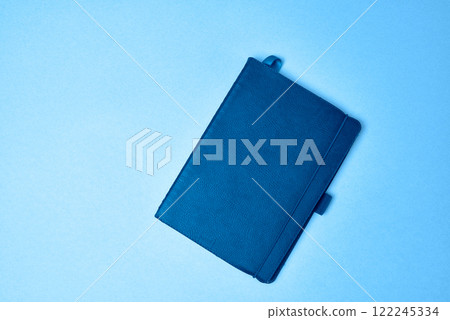 Minimalist Blue Notebook on a Bright Background. Minimalist Blue Notebook on a Bright Background. 122245334