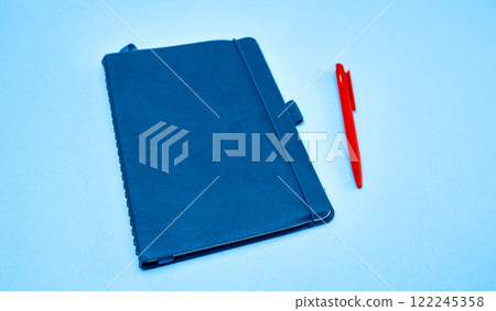 Blue Notebook and Red Pen on Light Background. Blue Notebook and Red Pen on Light Background. 122245358