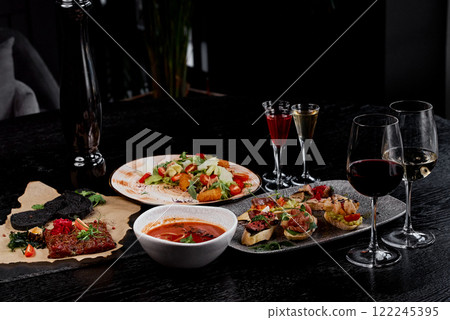 Refined Dining Table with Appetizers, Soup, and Wine. Refined Dining Table with Appetizers, Soup, and Wine. 122245395