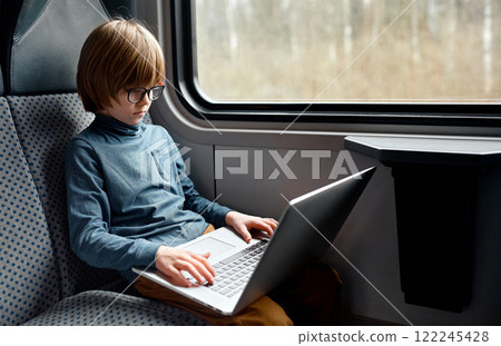 Young Boy with Glasses Typing on Laptop. 122245428