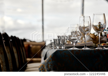 Elegant Glassware on Dining Table Overlooking Scenic View. Elegant Glassware on Dining Table Overlooking Scenic View. 122245446