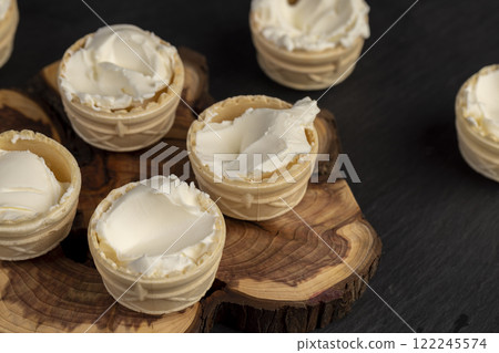 waffle cups with buttercream during dessert cooking waffle cups with buttercream during dessert cooking 122245574