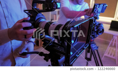 Cameraman hand. Video studio. Unrecognizable male operator work with professional filming equipment set. Modern technology photo recording shoot. Cameraman hand. Video studio. Unrecognizable male operator work with professional filming equipment set. Modern technology photo recording shoot. 122246660