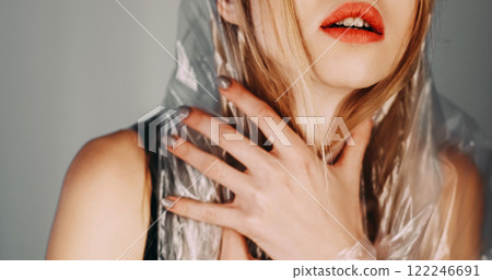 Anxiety problem. Panic attack. Art portrait of disturbed paranoid insecure woman wearing polyethylene film hood suffering isolated on gray background. 122246691