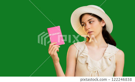 Disappointed young woman in summer hat holding a pink passport document isolated on green copy space background. Disappointed young woman in summer hat holding a pink passport document isolated on green copy space background. 122246838