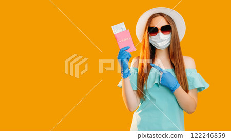 Pandemic travel. Global immigration. Woman tourist in protective face mask gloves showing id passport flight ticket isolated on orange copy space background. 122246859