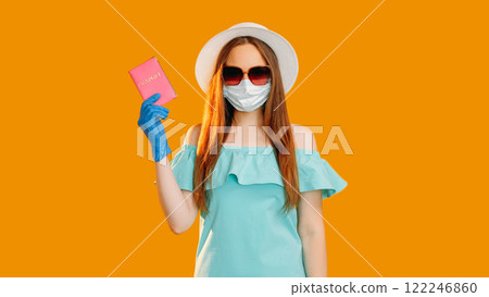 Pandemic tourism. Summer vacation. Woman in protective face mask gloves sunglasses holding id passport isolated on orange copy space background. 122246860