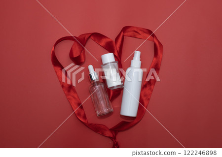 cosmetic face serum, enzyme face wash powder and cosmetic face spray in abstract red heart from red satin ribbon, love concept cosmetic face serum, enzyme face wash powder and cosmetic face spray in abstract red heart from red satin ribbon, love concept 122246898