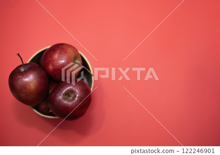 ripe red apples in a large paper cup on a red background ripe red apples in a large paper cup on a red background 122246901