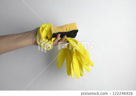 Household concept. Hand holding yellow gloves for cleaning with sponge Household concept. Hand holding yellow gloves for cleaning with sponge 122246926
