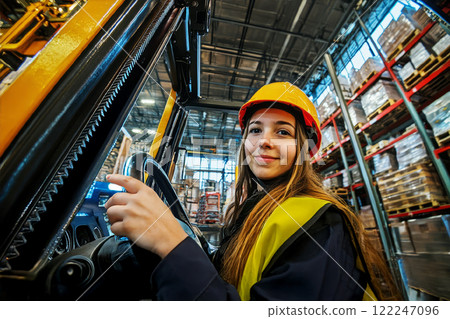 Woman operator electric counterbalance forklift truck in industrial warehouse. 122247096