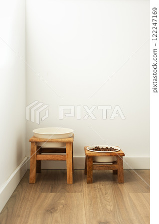 Dog feeding bowls on wooden stand. Water and biscuit pet food modern home corner, vertical Dog feeding bowls on wooden stand. Water and biscuit pet food modern home corner, vertical 122247169