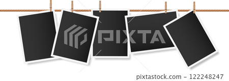 Five blank instant photographs are hanging on a clothesline held by wooden clothespins, creating a nostalgic display of memories yet to be made 122248247