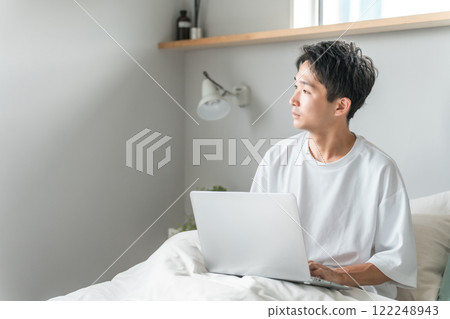 早上在家工作、遠距辦公、遠距工作或在家工作時在臥室使用電腦的男性 早上在家工作、遠距辦公、遠距工作或在家工作時在臥室使用電腦的男性 122248943