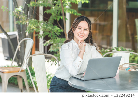 A business woman (nomad worker) who does nomad work/remote work at the terrace seat of a cafe 122249214