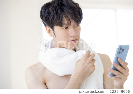 美圖：一名男子洗完澡後看智慧型手機 122249696