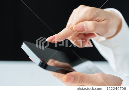 Hands touching the screen of a smartphone Hands touching the screen of a smartphone 122249706