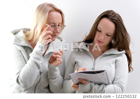 teacher student notebook helping girl in classroom for knowledge, helping schoolgirl and teach her to draw. Education concept teacher student notebook helping girl in classroom for knowledge, helping schoolgirl and teach her to draw. Education concept 122250132