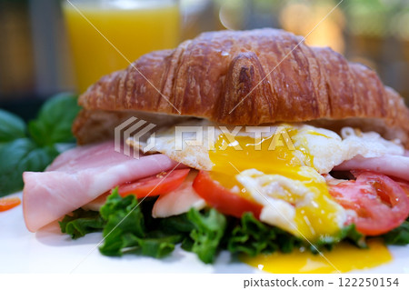Female hands putting different sandwiches on board during meal serving 122250154