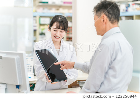 藥劑師/配藥員在藥房使用平板電腦(收據計算機/收據計算機)時進行說明 藥劑師/配藥員在藥房使用平板電腦(收據計算機/收據計算機)時進行說明 122250944