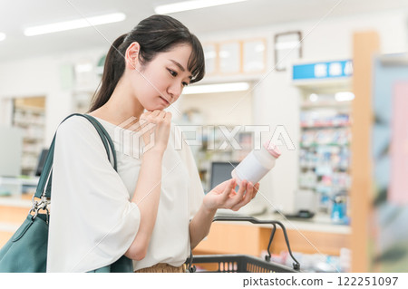 A woman shopping at a pharmacy, drug store, or convenience store 122251097