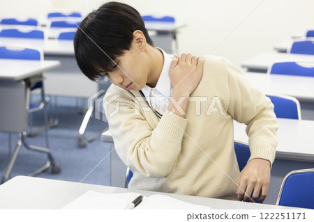A student suffering from stiff shoulders A student suffering from stiff shoulders 122251171