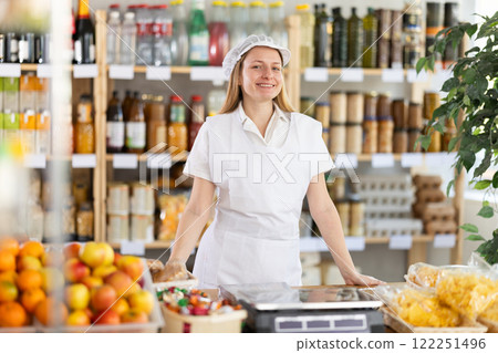 Young woman seller at counter in grocery store 122251496